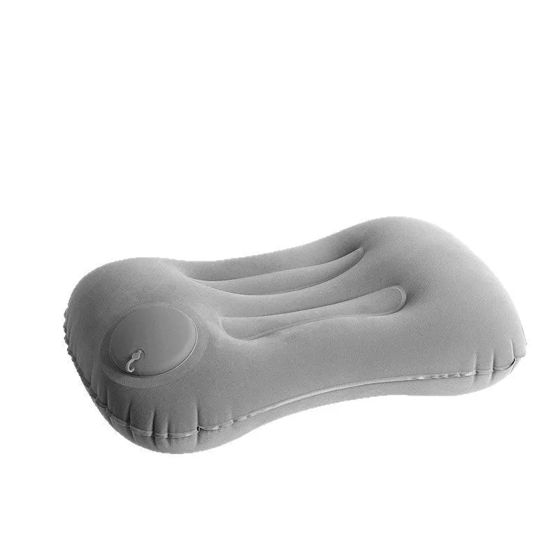 Grey inflatable travel pillow with soft flocking surface, shown deflated and inflated.