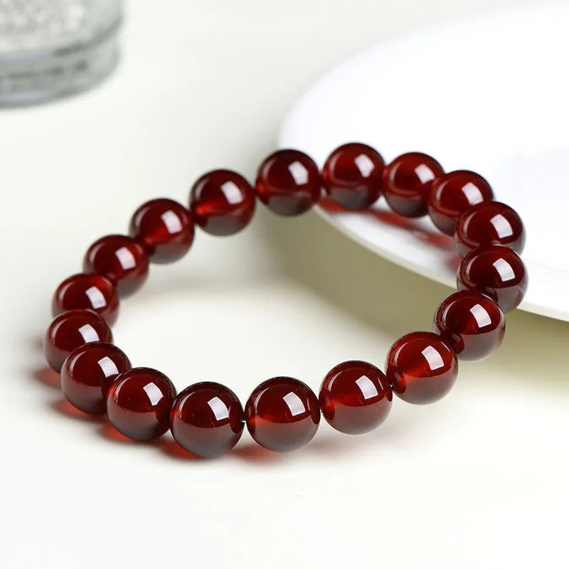 Natural orange red garnet ball bracelet with Ruyi design elements on crystal beads