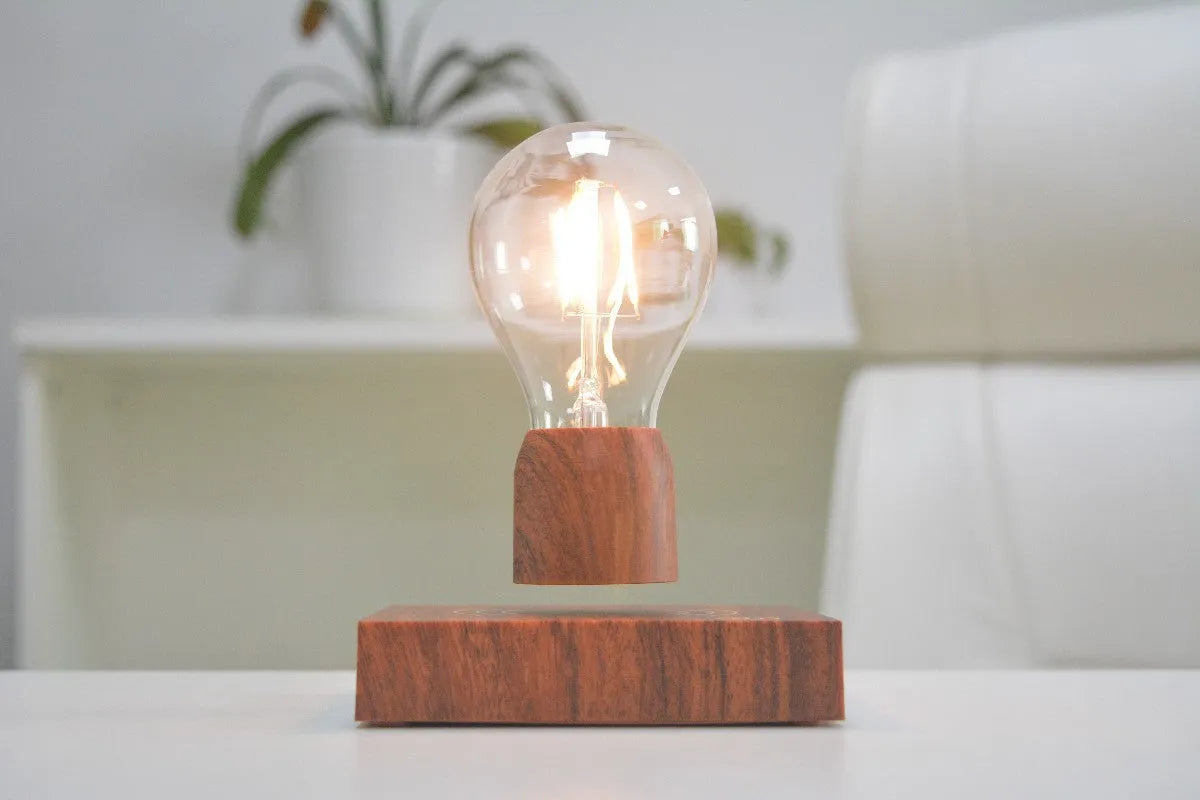 Magnetic levitation desk lamp with floating light bulb on imitation wood base.