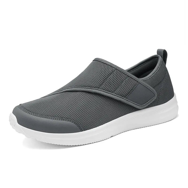 A pair of grey mesh walking shoes with a Velcro strap closure, shown on a white background.
