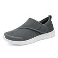 A pair of grey mesh walking shoes with a Velcro strap closure, shown on a white background.