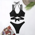 Women's solid colour strap bikini swimsuit on a hanger, shown in red.