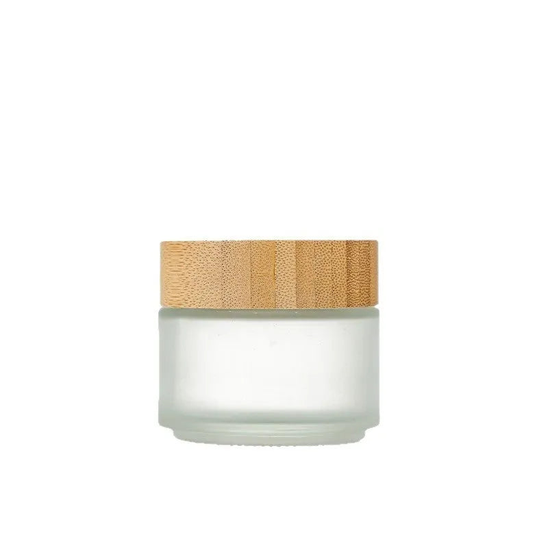 Glass cream jar with bamboo wood lid in frosted finish for facial skincare storage