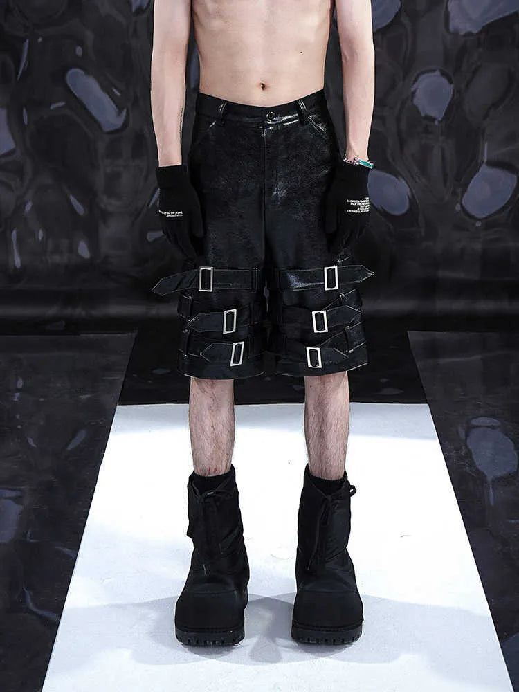 Black men's PU leather casual shorts with ring detailing, shown in a cropped pants style.