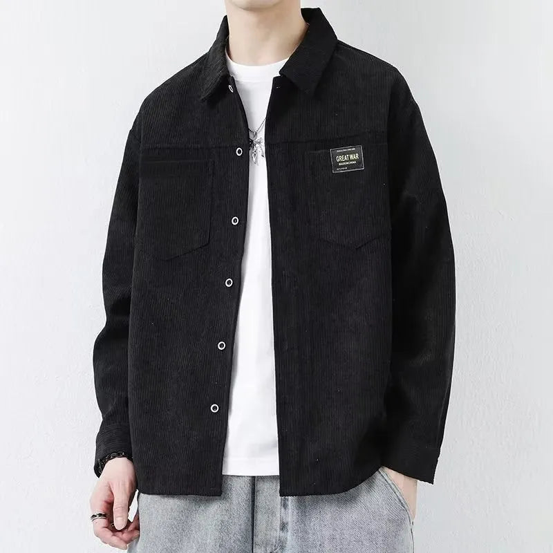 Man wearing a dark grey corduroy cardigan-style jacket with long sleeves.
