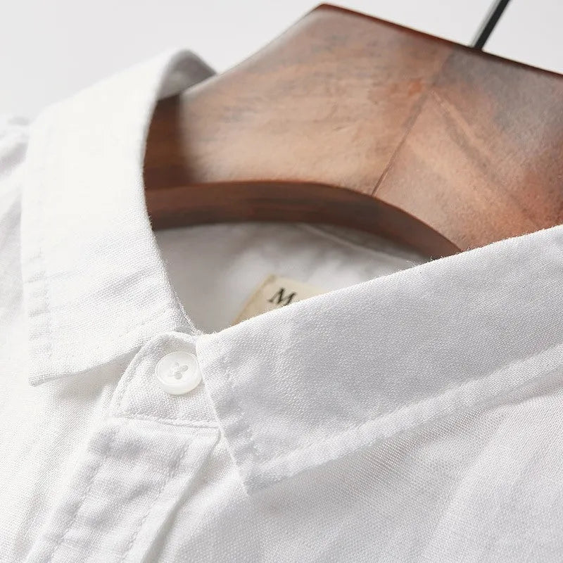Men's light blue linen short sleeve shirt with a square collar on a hanger.