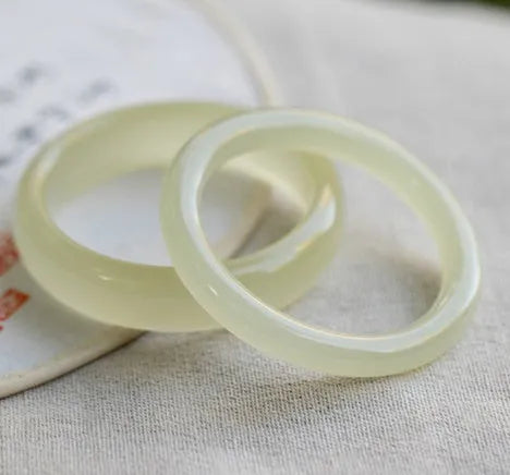 Round bar jade bracelet with winding silk texture showing circular geometry and polished surface