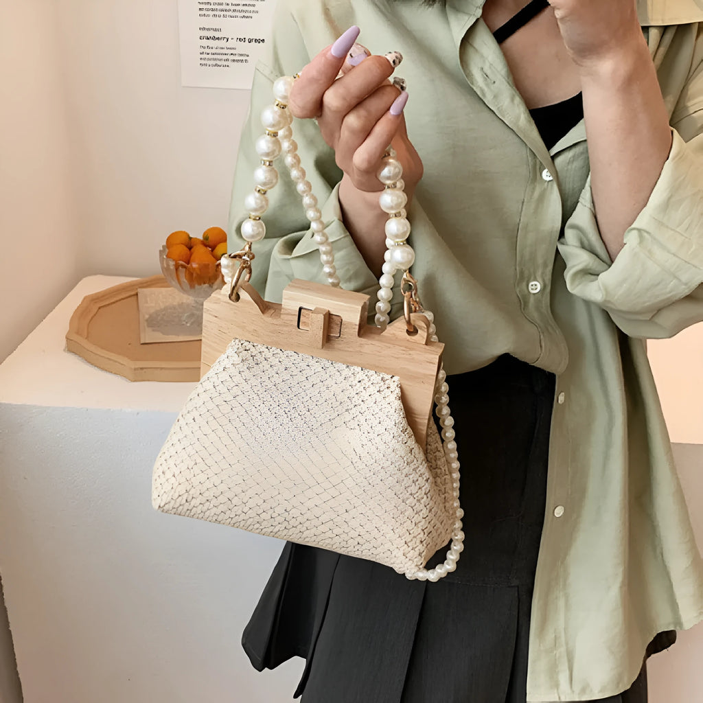 Women's woven straw shoulder bag with pearl chain strap in beige, showing internal organiser pockets.