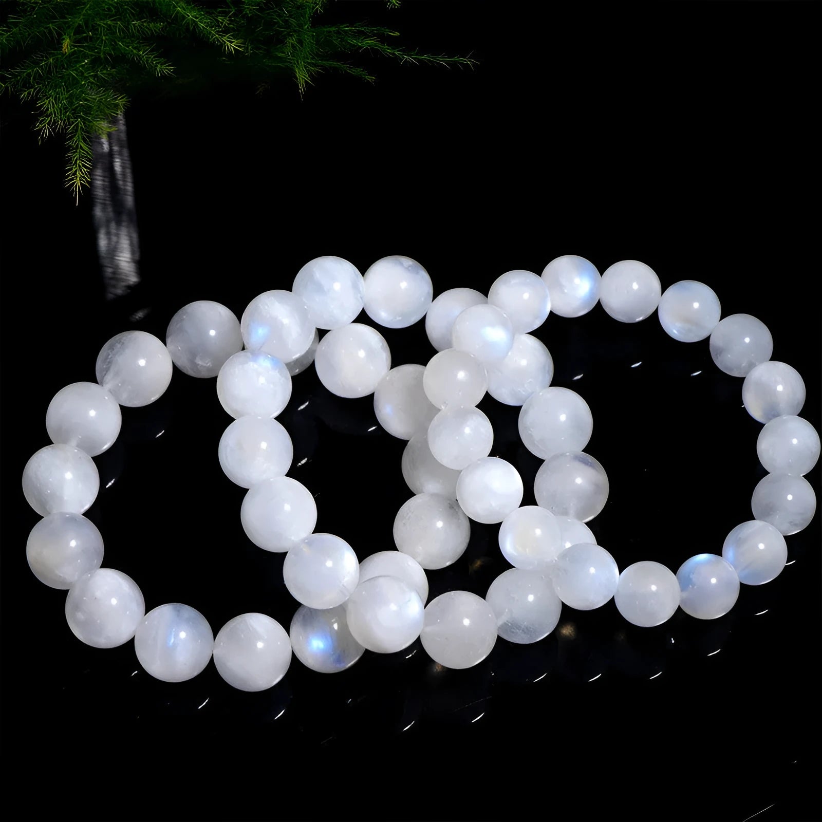 Natural white Moonstone round bead bracelet on a wrist, showing polished geometry beads.