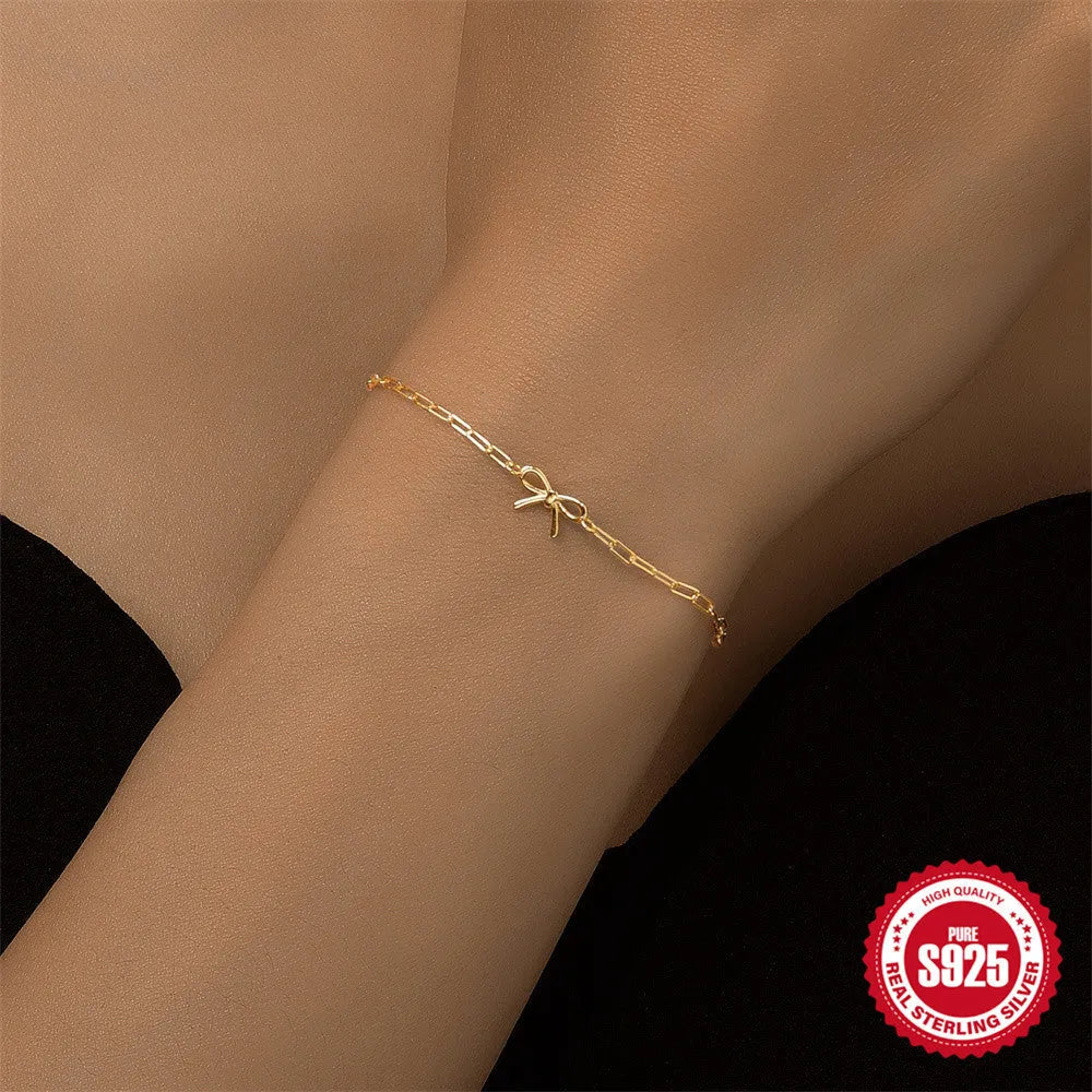 Close-up of a women's sterling silver bracelet with a glossy heart charm on an adjustable clip chain.