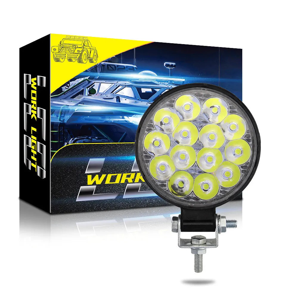 Compact round aluminium LED work light with white light, suitable for vehicle mounting.