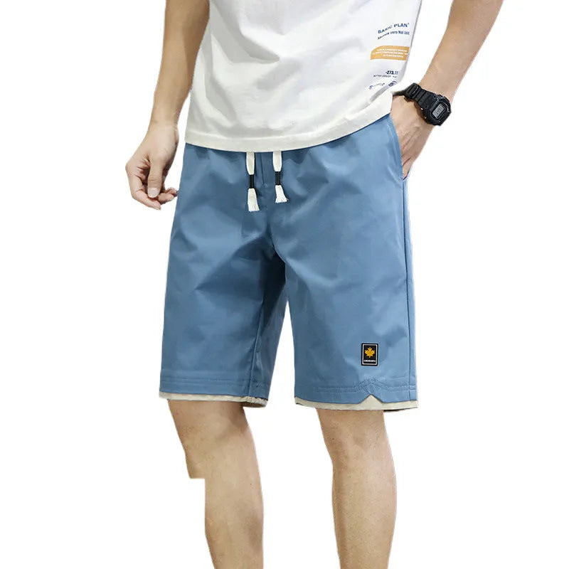 Man wearing loose-fitting straight-leg beach shorts in a khaki colour, showing Korean style and casual fit.