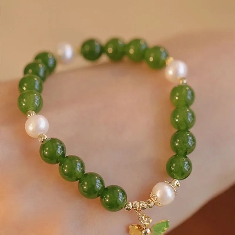 Natural green chalcedony bracelet with round geometric beads on a wrist.