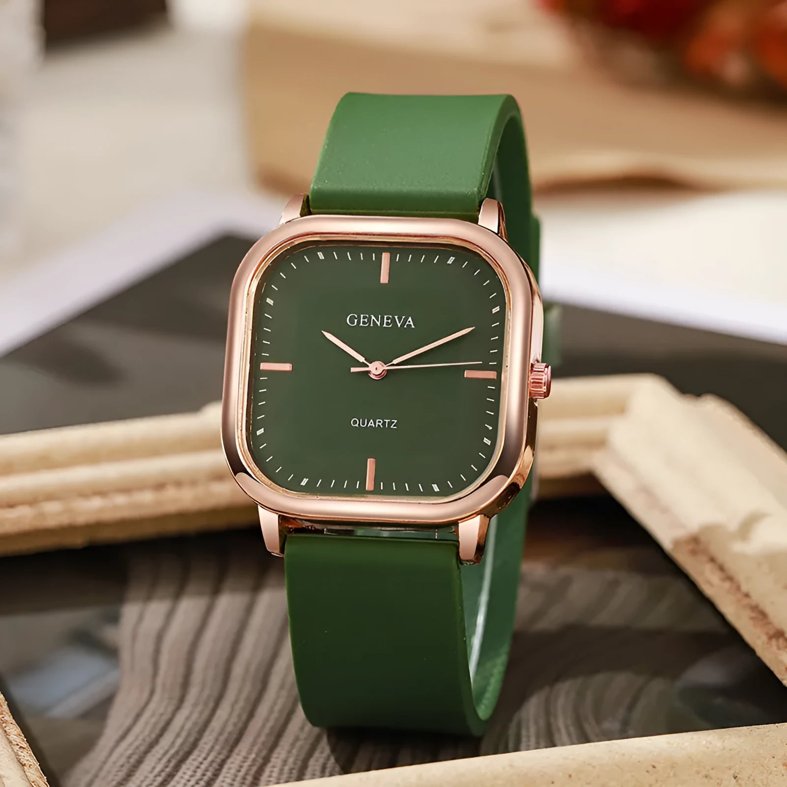 Women's rose gold square dial quartz watch with plastic strap on white background