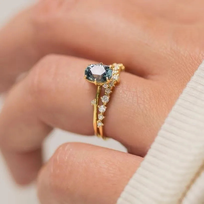 Gold plated women's flower-shaped ring with a green zircon stone, shown in a pair.