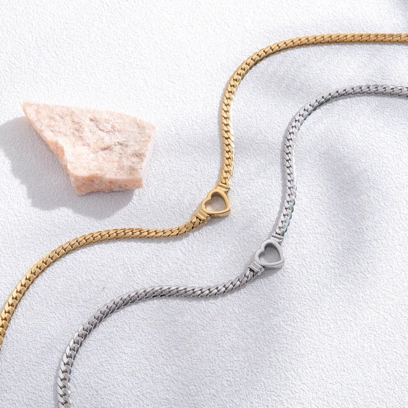Fashion simple hollow heart titanium steel bracelet in BR-26 gold finish on a neutral background