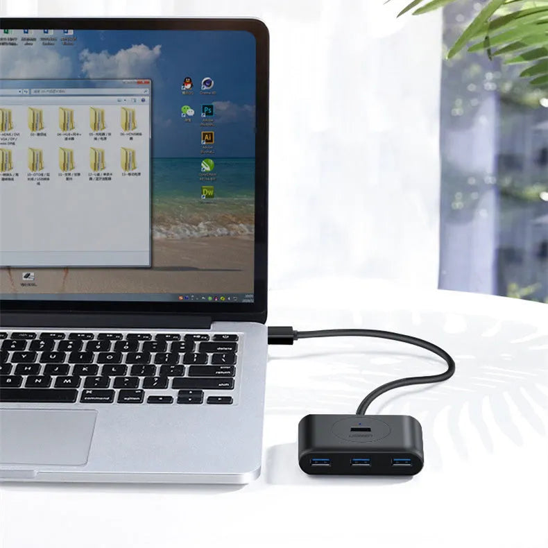 Deep black USB splitter hub with four ports, ABS plastic shell, and indicator light on desk