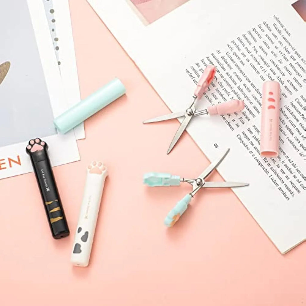 Cat paw cartoon design mini folding safety scissors in four colours: black, blue, pink, and white.