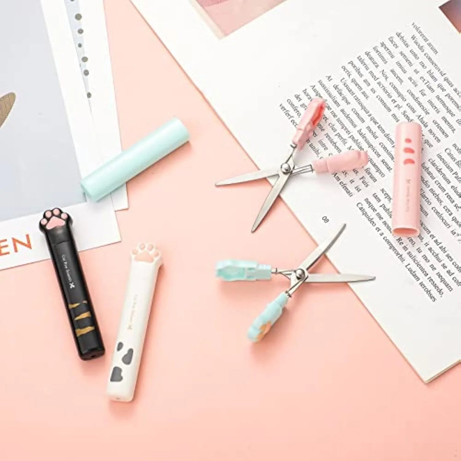 Cat paw cartoon design mini folding safety scissors in four colours: black, blue, pink, and white.