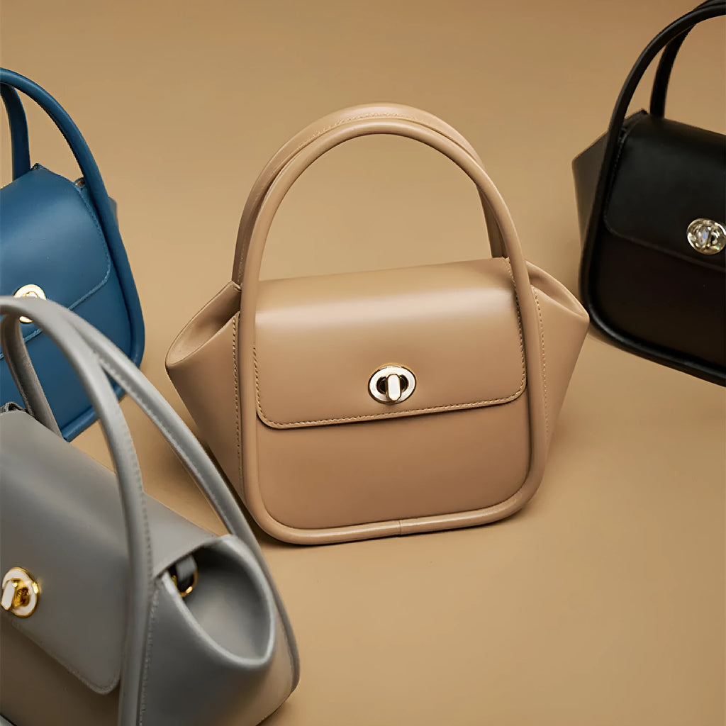 Women's leather wing shape tote bag with cross-body strap in four colour options showing buckle detail