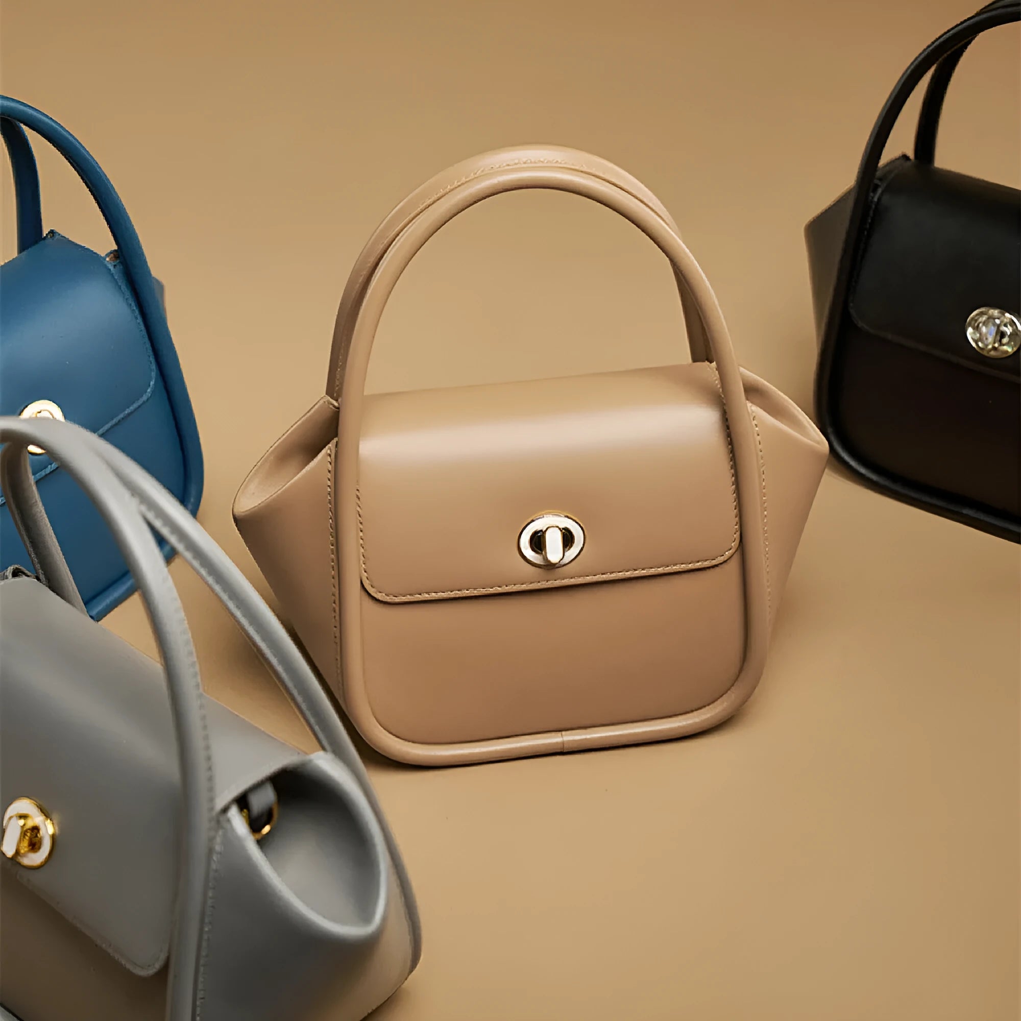 Women's leather wing shape tote bag with cross-body strap in four colour options showing buckle detail