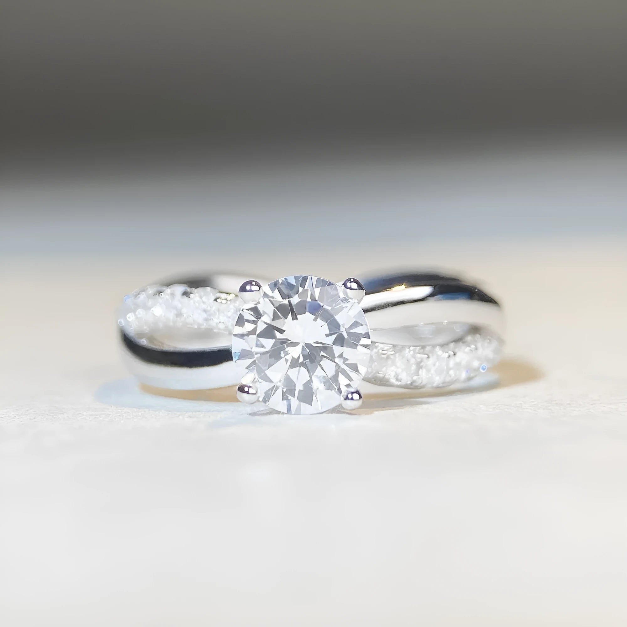 Geometric silver ring with a 1 karat moissanite stone in a four-claw setting and twisted arm band.