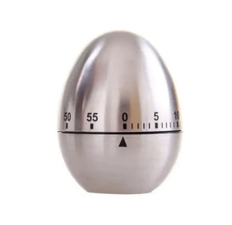 Stainless steel egg-shaped mechanical kitchen timer on a kitchen worktop.