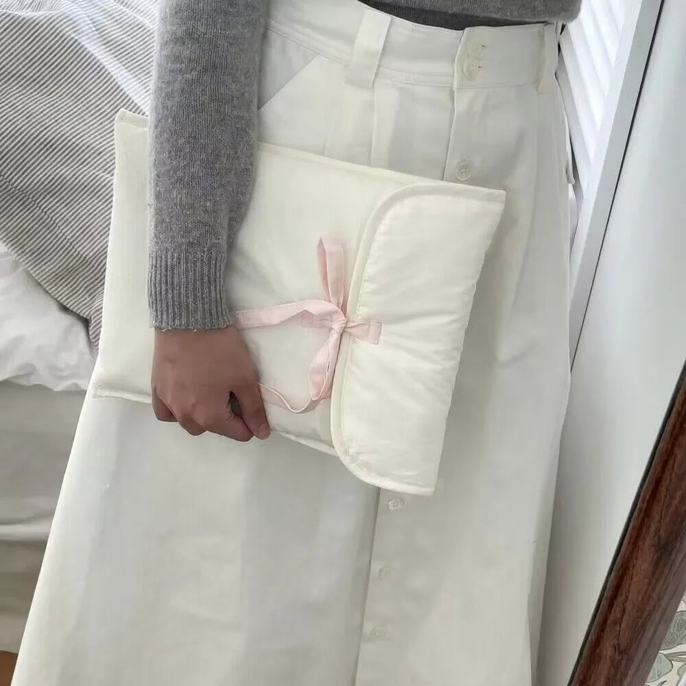 Black and white quilted women's laptop bag with a large decorative ballet bow on the front.