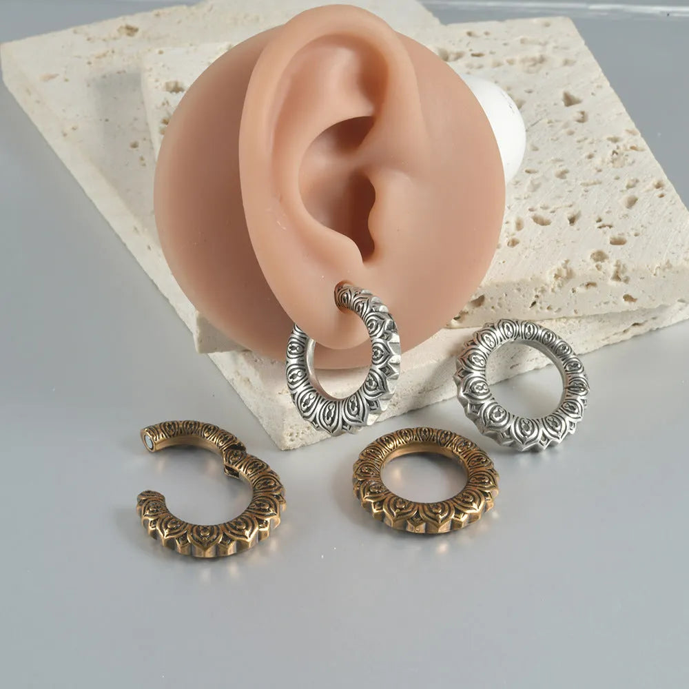 Large antique silver dragon-shaped hollow out copper auricle earrings on a white background.