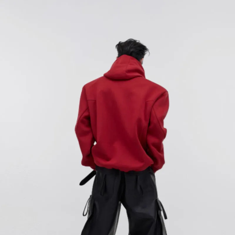 A loose red men's hooded sweater with heavy shoulder pads and metallic silver printing on the front.