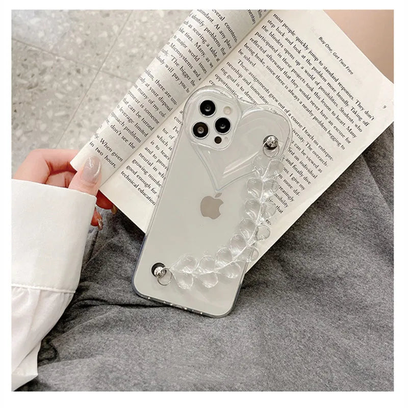 Transparent clear iPhone case with a love heart chain design on a smartphone.