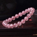 Women's strawberry quartz crystal bracelet with polished beads in 6mm, 8mm, or 10mm sizes.