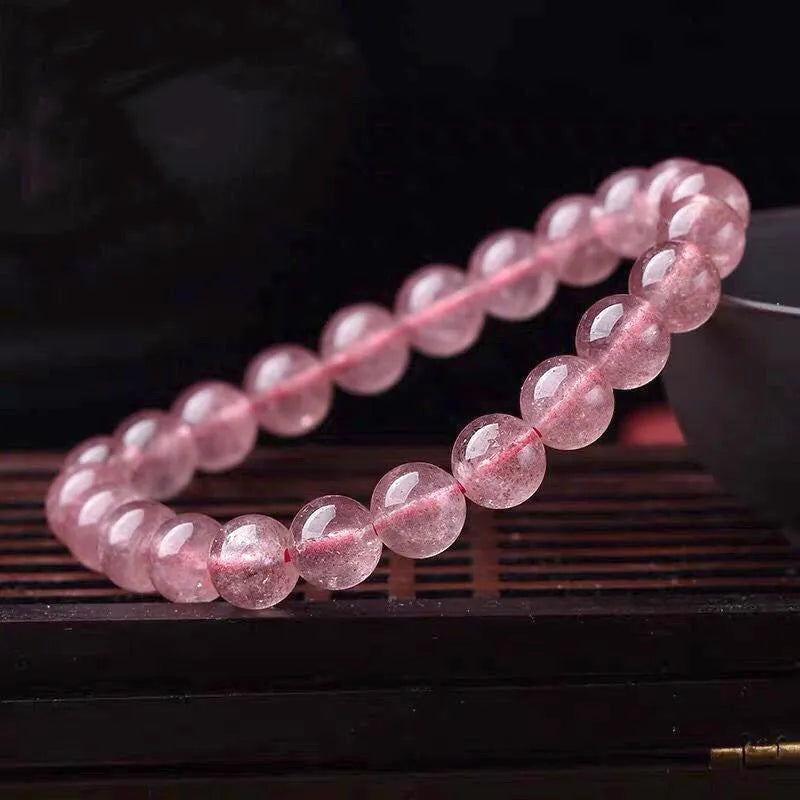 Women's strawberry quartz crystal bracelet with polished beads in 6mm, 8mm, or 10mm sizes.