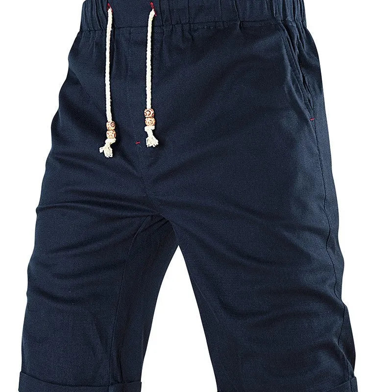 Men's solid colour cotton blend shorts with a drawstring waist and zipper pocket, shown in straight fit.