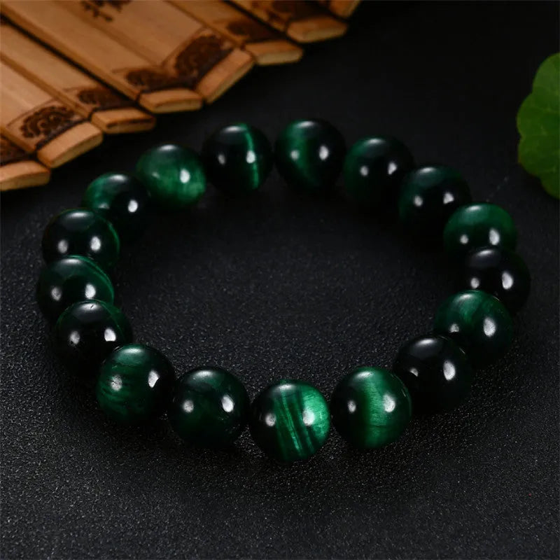 Green tiger eye stone bracelet with geometric shaped beads on a white background.