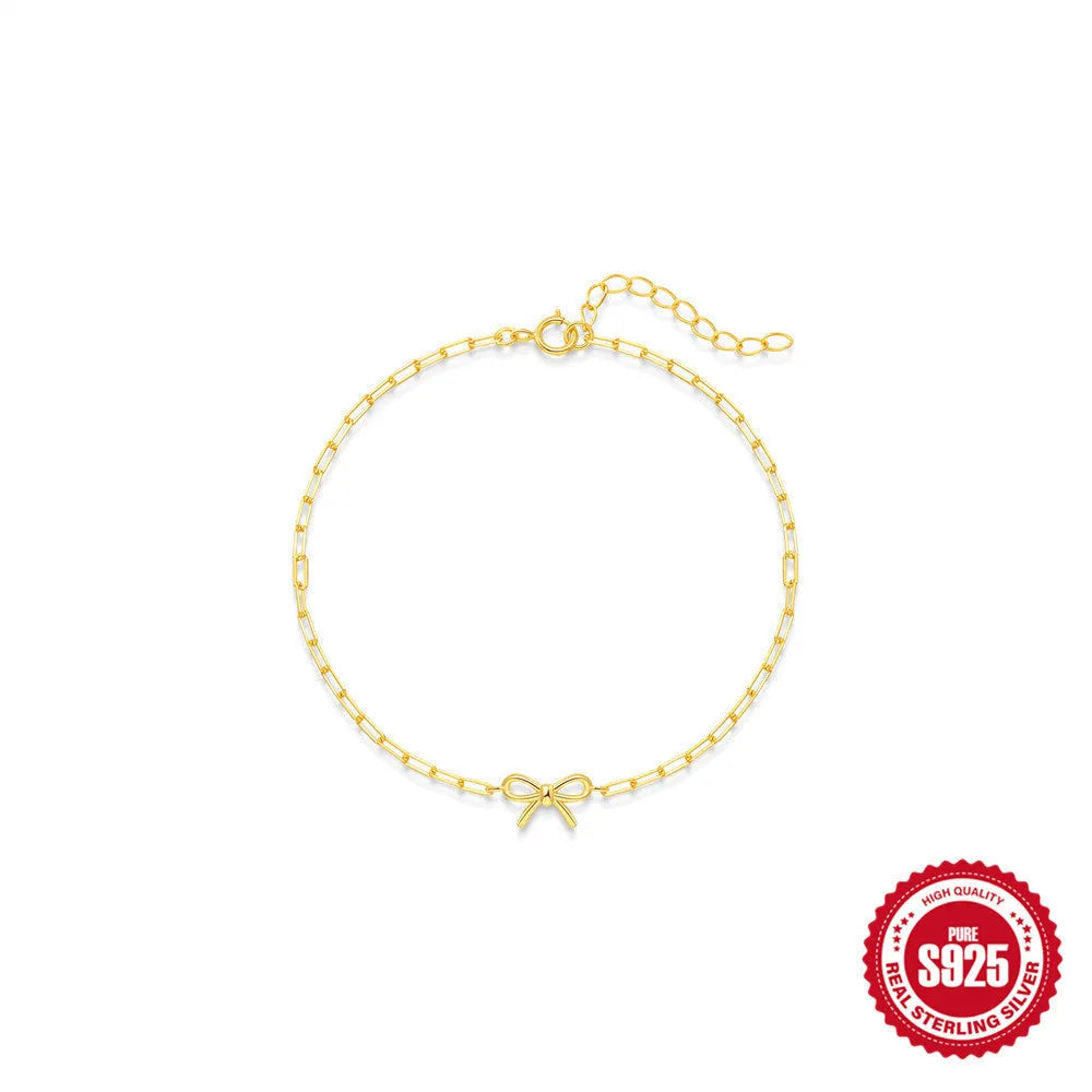 Close-up of a women's sterling silver bracelet with a glossy heart charm on an adjustable clip chain.