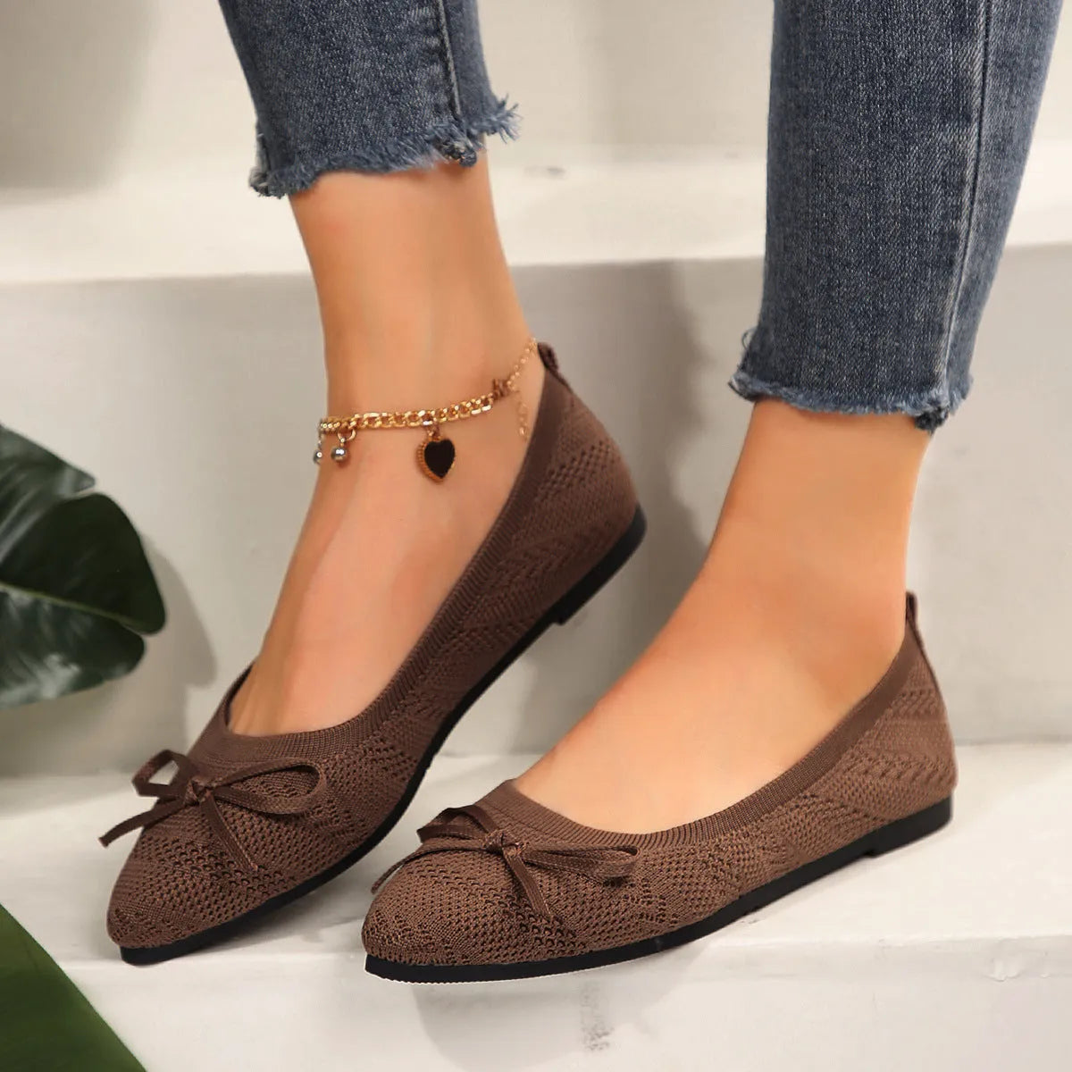 Women's blue knitted flat loafers with a bow and pointed toe on a rubber sole.