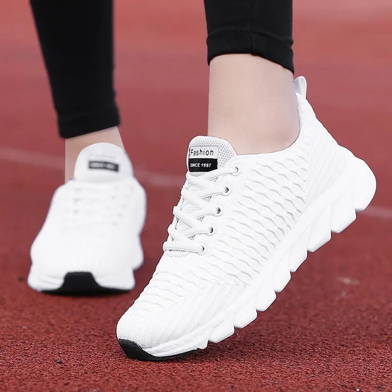 Women's running shoes in black with detailed view of fly weaving upper material and wear-resistant rubber outsole.