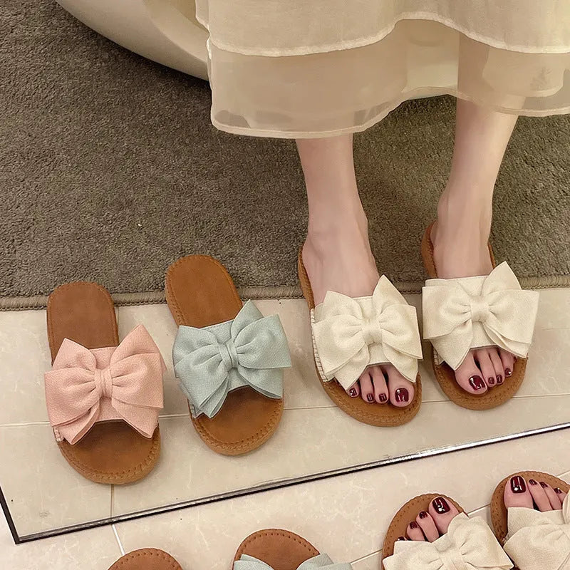 Women's slip-on cloth sandals with bow detail in beige, light green, and pink colours