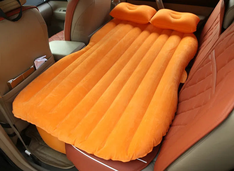 Black inflatable car bed with flocked material laid out in a five-seater vehicle boot.