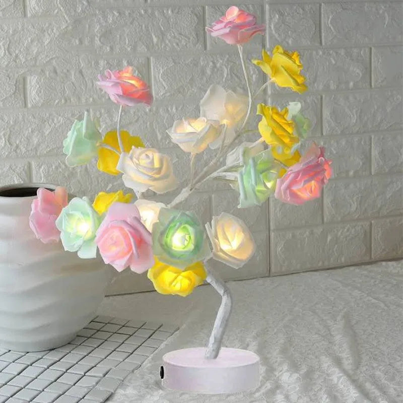 White and red rose flower shaped USB battery LED table lamp with warm white light on a table.