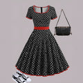 Multicolour polka dot pleated dress with square collar and short sleeves on a hanger.