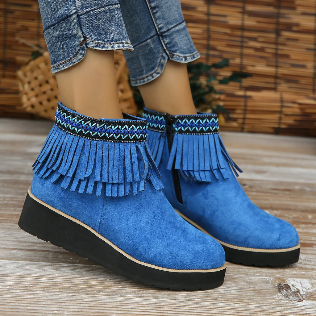 Women's black suede wedge ankle boots with side zipper, tassel detail, and thick rubber sole.