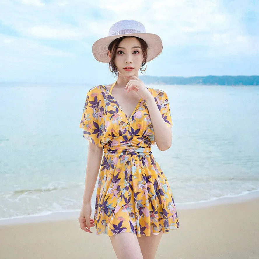 Yellow floral pattern women's one-piece swimsuit on a hanger showing front design