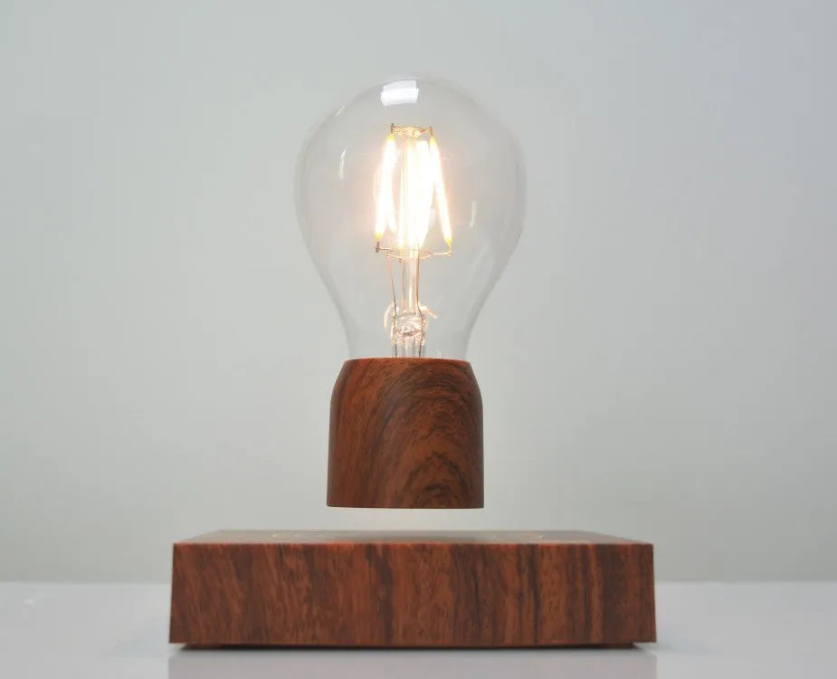 Magnetic levitation desk lamp with floating light bulb on imitation wood base.