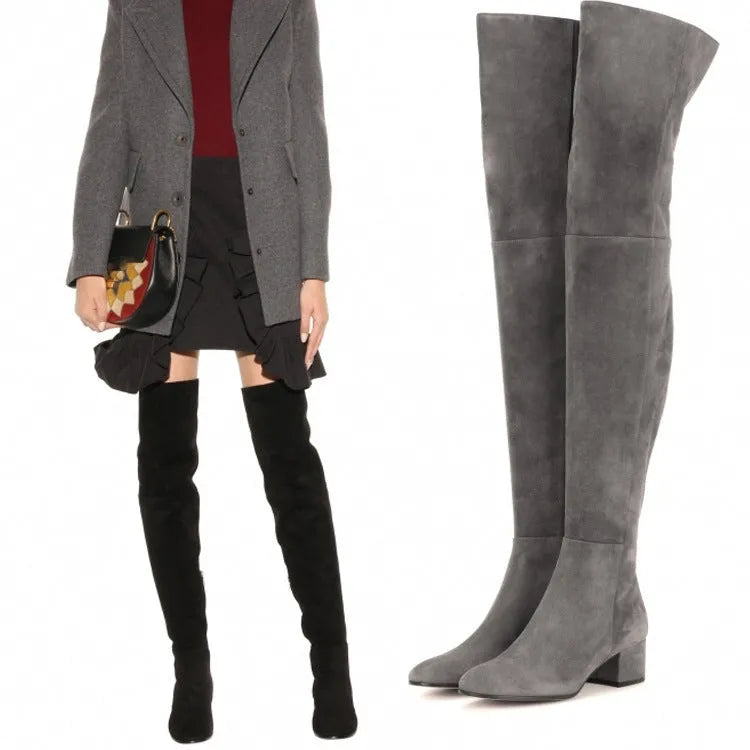 Grey suede women's over the knee flat boots with a pointed toe and thick low heel on a neutral background.