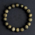 Natural obsidian crater ball bracelet with textured beads in gold or silver stone finish on a wrist.