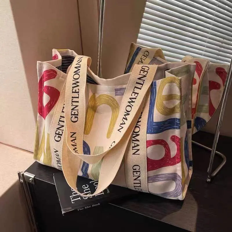 Large canvas women's travel tote bag with shoulder strap and printed design