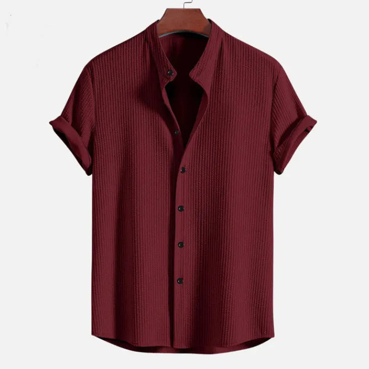 Man wearing a loose-fitting short sleeve summer shirt in a solid colour, showing the relaxed fit and short sleeves.