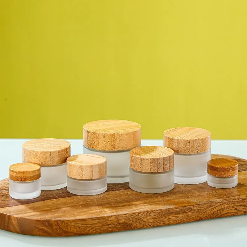 Glass cream jar with bamboo wood lid in frosted finish for facial skincare storage
